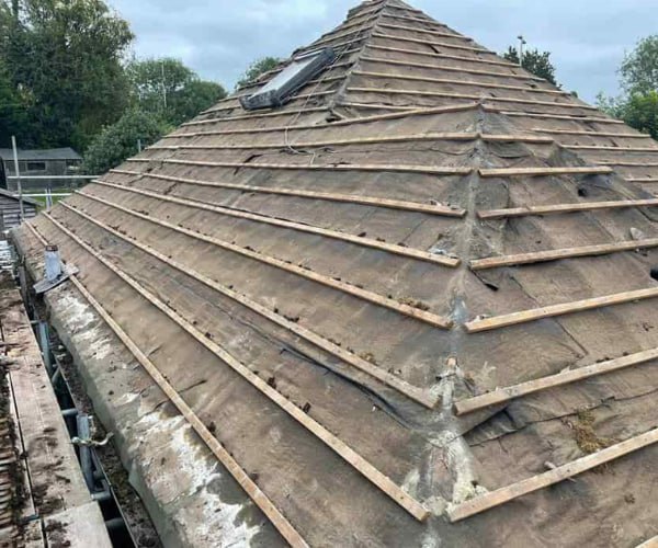 This is a photo of a hip roof that has been stripped back to the battens, and is awaiting a new roof covering to be installed. Works carried out by DSC Roofing Rushden